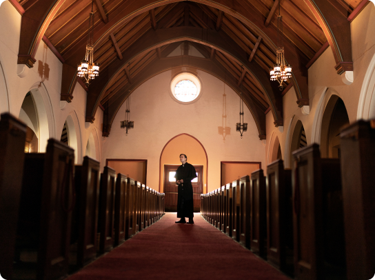 Priest praying in church
